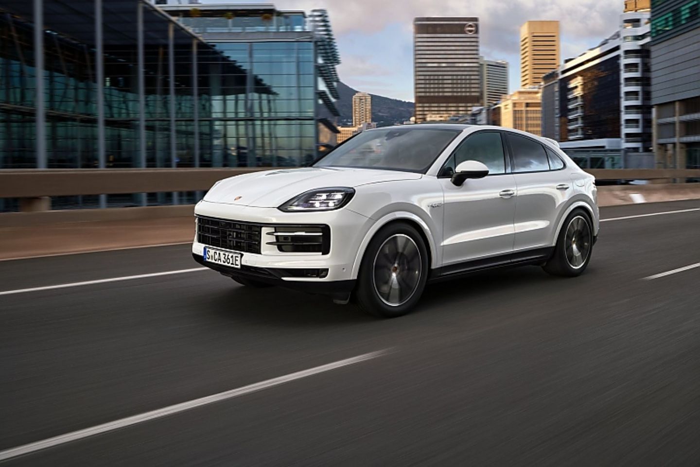 Modellpflege 2023 Porsche Cayenne E-Hybrid Coupé Der neue Porsche Cayenne fährt auf einer Straße durch städtische Umgebung