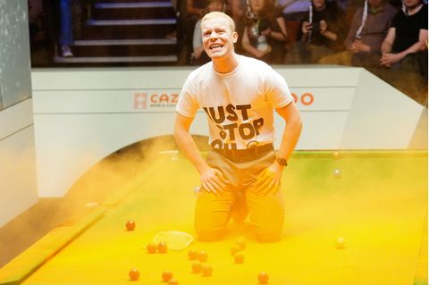 Ein Klimaprotestierer verteilt in Sheffield während einer WM-Partie oranges Pulver auf dem Billardtisch