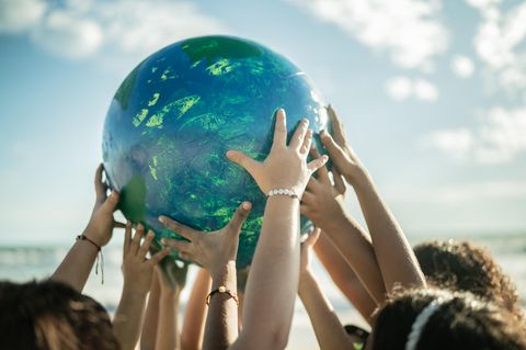 Tag der Erde: Ein von vielen Händen getragener Globus als Symbolfoto für den Earth Day