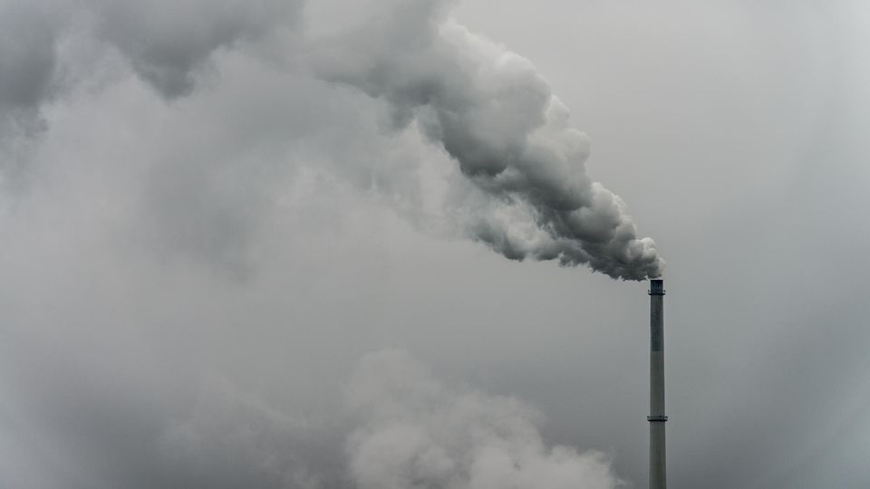Qualm steigt aus dem Schornstein einer Fabrik – EU-Parlament weitet den Emissionshandel aus