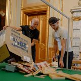 Zwei Männer mit Karton voller Playmobilteilen