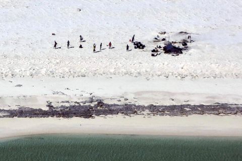 Fischer aus Indonesien stehen auf einem Strand auf Bedwell Island