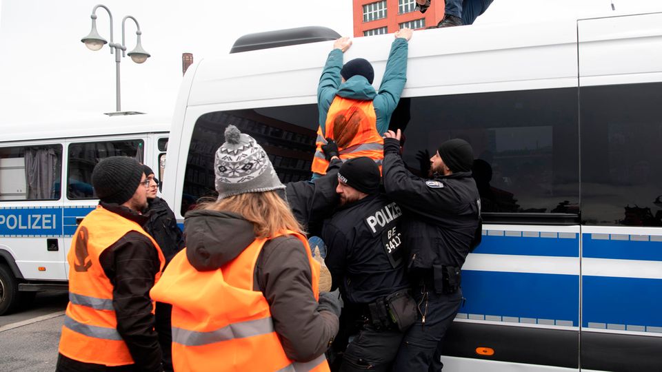 Berlin: An activist from the last generation tries to climb onto a police car during a demonstration.