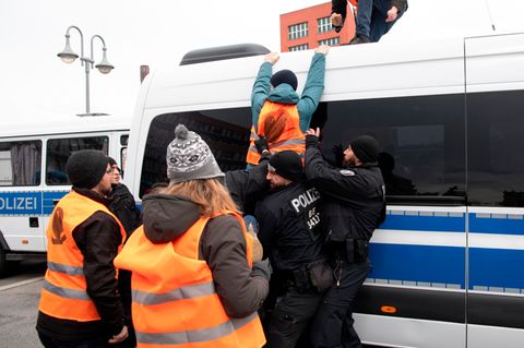 Berlin: Ein Aktivist der Letzten Generation versucht bei einer Demonstration auf ein Polizeiwagen zu klettern.