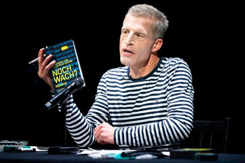 Benjamin von Stuckrad-Barre hält sein neues Buch in der Hand und eine Zigarette