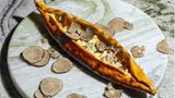 Pide mit Trüffel und Traubendicksaft  Zutaten:  1 Portion Cüisine-Teig, geviertelt  Zubereitung:  Vorteig  30 g Wasser  30 g Weißmehl (Weizenmehl; Type 400 oder 405)  1 g frische Hefe (bio)  Alle Zutaten von Hand gut miteinander vermengen. Den Vorteig in einem geschlossenen Behälter 24 Stunden an einem dunklen Ort bei Raumtemperatur gehen lassen.  Hauptteig  61 g Vorteig  355 g lauwarmes Wasser  535 g Weißmehl (Weizenmehl; Type 400 oder 405)  2 g frische Hefe (bio)  10 g Salz  Alle Zutaten außer dem Salz in die Schüssel einer Küchenmaschine geben und mit dem Knethaken auf niedrigster Stufe 8 Minuten kneten lassen. Alternativ das Handrührgerät mit Knethaken verwenden. Das Salz beifügen und weitere 3 Minuten auf der nächsthöheren Stufe kneten lassen.  Den Teig in 50 g oder 100 g schwere Teiglinge portionieren und bis zu 24 Stunden im geschlossenen Behälter (oder zugedeckt, damit der Teig nicht austrocknet) an einem dunklen Ort bei Raumtemperatur aufgehen lassen.      Für den Belag:  - 300 g Pide-Käsemischung (100 g Cheddar, 100 g Emmentaler, 400 g Frischkäse, 300 g Salzlakenkäse)  - 300 g Trüffel-Brie  - Weißmehl (Weizenmehl) zum Ausrollen  - Traubendicksaft  - frischer Trüffel, min. 10 g pro Person      Zubereitung:  1. Den Ofen mitsamt zwei Backblechen bei Ober-/Unterhitze auf die höchstmögliche Temperatur vorheizen.  2. Die Teiglinge von Hand mithilfe von viel Mehl flach drücken und mit einem Nudelholz zu ovalen Fladen ausrollen, dann so viel Mehl wie möglich wieder von den Teigfladen abklopfen.  3. Die Käsemischung gleichmäßig auf den Fladen verteilen, sodass auf allen Seiten ein Rand von etwa 1 cm frei bleibt. Dann den Trüffel-Brie punktuell mithilfe eines Löffels darauf verteilen.  4. Die Pides im vorgeheizten Ofen auf den heißen Backblechen 15–20 Minuten knusprig ba- cken, bis sie eine goldbraune Farbe annehmen.  5. Die fertig gebackenen Pides aus dem Ofen nehmen und den Rand üppig mit Traubendicksaft bepinseln. Den Trüffel sofort darüberhobeln und die Pides heiß servieren.