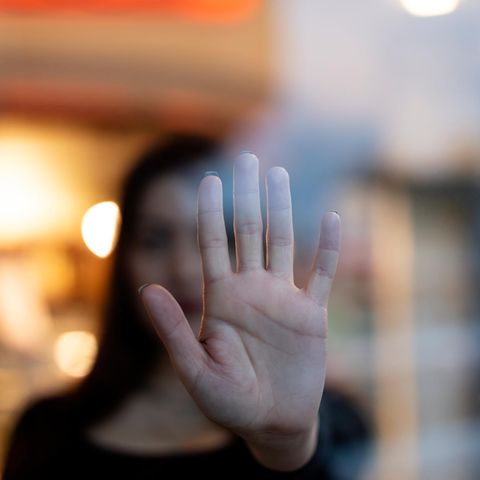 Frau und Hand vor Glasscheibe