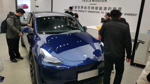 Kunden schauen sich ein ausgestelltes Auto von Tesla an