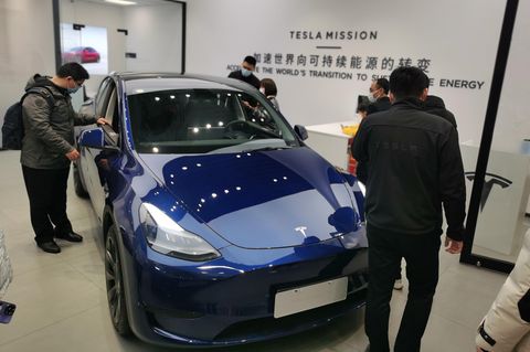 Kunden schauen sich ein ausgestelltes Auto von Tesla an