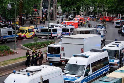 Einsatzkräfte stehen auf der abgesperrten Straße