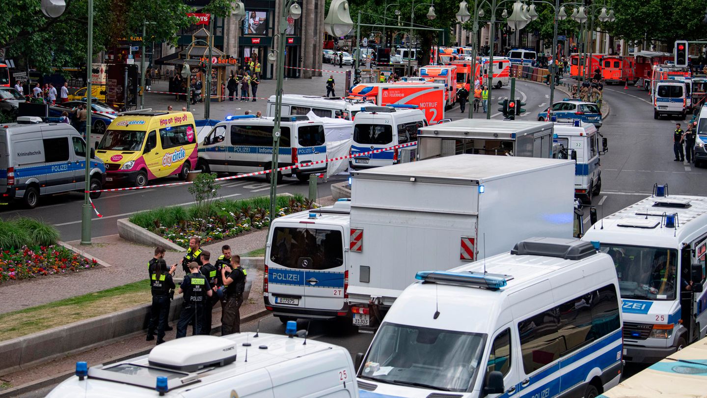 Einsatzkräfte stehen auf der abgesperrten Straße