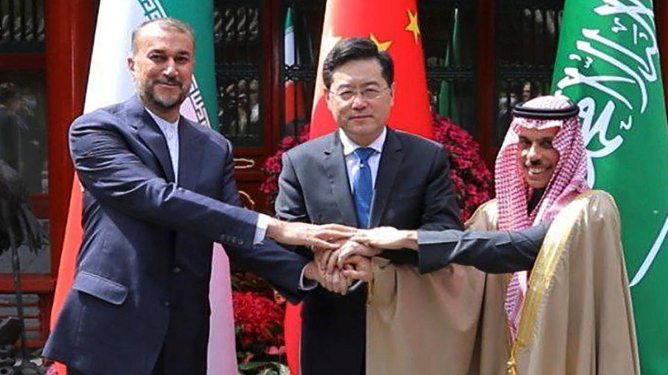 Die Außenminister des Iran (l.), von China (M.) und Saudi-Arabien reichen sich die Hand