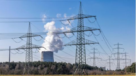 Das Atomkraftwerk Emsland in Lingen, davor elektrische Freileitungen