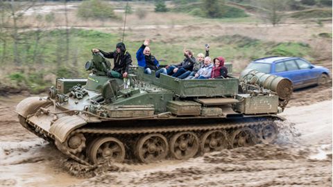 Zivilisten fahren auf einem T55TK Bergepanzer mit