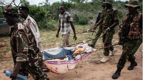 Kenia: Sicherheitskräfte tragen einen geretteten jungen Menschen aus dem Wald in Shakahola