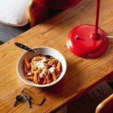 Schnelle Ajvar-Pasta mit Crème fraîche  Nach einer langen Fahrt und dem Bezug der Ferien- wohnung hat niemand Lust, lang am Herd zu stehen. Gefragt sind aber neue Energie und ein warmes Es- sen. Die Paprika-Pasta ist ungefähr so schnell fertig, wie die Nudeln zum Garen brauchen. So fängt guter Urlaub an!      Zutaten:  Für 4 Personen  Fertig in 15 Minuten  - 1 Zwiebel  - 1 Knoblauchzehe  - 4 EL Olivenöl  - 200 g Ajvar (milde Paprika-Paste aus dem Glas)  - 300 ml Gemüsebrühe  - 350–400 g Penne-Nudeln  - Salz  - 100 g Parmesan, Pecorino oder Grana Padano  - 150 g Kräuter-Crème-fraîche (wahlweise Crème fraîche)      Zubereitung:  1. Zwiebel und Knoblauch halbieren, pellen und fein würfeln, in einer Pfanne im Öl glasig dünsten. Ajvar und Brühe zugeben, aufkochen und leise offen köcheln. Währenddessen die Nudeln nach Packungsanweisung in kräftig gesalzenem Wasser garen.  2. Den Käse reiben. Die Nudeln abgießen, abtropfen lassen und heiß mit der Sauce vermengen. Mit Crème fraîche und geriebenem Käse getoppt servieren.