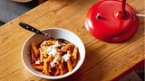 Schnelle Ajvar-Pasta mit Crème fraîche  Nach einer langen Fahrt und dem Bezug der Ferien- wohnung hat niemand Lust, lang am Herd zu stehen. Gefragt sind aber neue Energie und ein warmes Es- sen. Die Paprika-Pasta ist ungefähr so schnell fertig, wie die Nudeln zum Garen brauchen. So fängt guter Urlaub an!      Zutaten:  Für 4 Personen  Fertig in 15 Minuten  - 1 Zwiebel  - 1 Knoblauchzehe  - 4 EL Olivenöl  - 200 g Ajvar (milde Paprika-Paste aus dem Glas)  - 300 ml Gemüsebrühe  - 350–400 g Penne-Nudeln  - Salz  - 100 g Parmesan, Pecorino oder Grana Padano  - 150 g Kräuter-Crème-fraîche (wahlweise Crème fraîche)      Zubereitung:  1. Zwiebel und Knoblauch halbieren, pellen und fein würfeln, in einer Pfanne im Öl glasig dünsten. Ajvar und Brühe zugeben, aufkochen und leise offen köcheln. Währenddessen die Nudeln nach Packungsanweisung in kräftig gesalzenem Wasser garen.  2. Den Käse reiben. Die Nudeln abgießen, abtropfen lassen und heiß mit der Sauce vermengen. Mit Crème fraîche und geriebenem Käse getoppt servieren.