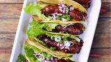 Chorizo-Tacos mit schwarzen Bohnen  Gut, dass es mittlerweile Soft-Tortilla-Fladen für Tacos vakuumiert im Supermarkt gibt. In der Kühltasche können sie unkompliziert mit auf die Reise gehen für leckere Grill-Tacos mit würziger Chorizo und cremigem Bohnenragout. Das lässt sich auch gut am Vortag zubereiten, es wird nach dem Aufwärmen nur besser.      Zutaten:  Für 4 Personen (bzw. 8 Tacos)  Fertig in 35 Minuten  - 1 Fleischtomate  - 1 Dose schwarze Bohnen (ca. 420 g EW, wahlweise Kidneybohnen oder weiße Bohnen)  - 2 rote Zwiebeln (Rotwein-)Essig Salz 4 EL Olivenöl  - 1 Knoblauchzehe  - 1 TL Tomatenmark  - 1–2 TL Ahornsirup oder Honig  - 200 ml Gemüsebrühe  - Chilisauce (z.B. Chipotles in Adobo oder Sriracha)  - 4 Römersalatblätter  - 1 Frühlingszwiebel  - 4 Chorizo-Würste  - 8 Tortilla-Fladen (ca. 10 cm Durchmesser)      Zubereitung:  1. Die Tomate würfeln. Die Bohnen abgießen und kalt abspülen, abtropfen lassen. Die Zwiebeln halbieren, pellen und fein würfeln. Die Hälfte davon mit Essig besprenkeln, salzen und beiseitestellen.  2. Die andere Hälfte der Zwiebeln in einer Pfanne in heißem Olivenöl glasig dünsten. Knoblauch pellen und fein gewürfelt mit den Tomaten zugeben. Tomatenmark und Ahornsirup unterrühren, die Bohnen zugeben. Brühe angießen und aufkochen. Offen 8–10 Minuten dicklich einkochen, mit Salz und Chilisauce würzen.  3. Salatblätter waschen und trockenschleudern. Frühlingszwiebel in feine Ringe schneiden und in kaltes Wasser legen. Die Chorizos längs halbieren und bei milder Hitze auf dem Grill oder auch in der beschichteten Pfanne ohne Fett 4–6 Minuten grillen oder braten.  4. Die Tortillas vor dem Erwärmen mit wenig Wasser anfeuchten und dann sekundenschnell auf dem Grill oder in einer Pfanne erwärmen. Mit je 1 Salatblatt, etwas Bohnenragout und 1⁄2 Chorizo füllen. Mit Essigzwiebeln und Frühlingszwiebeln getoppt servieren.