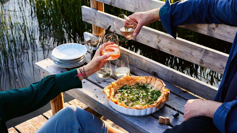 Tomaten-Ricotta-Tarte  Der Filo-Strudelteig rahmt knusprig die Füllung aus Ricotta, Kräuterfrischkäse und Tomaten. Nur die Erbsen dürfen erstmal nicht mit rein: Grün und knackig unterstützen sie auch optisch das Frühlingszwiebel- Dill-Topping. So geht Sommer, frisch aus dem Ofen!      Zutaten:  Für 4 Personen  Fertig in 30 Minuten (plus 35 Minuten Backzeit und 15 Minuten, um die fertige Tarte leicht abzukühlen)  - 2 Tomaten (250 g) Salz 2 Schalotten 1 Knoblauchzehe 250 g Ricotta  - 75 g Kräuterfrischkäse  - 50 g fein geriebener Parmesan  - 2 Eier (L)  - 1 TL fein geriebene unbehandelte Zitronenschale  - 1 Pkg. Filo- oder Yufka-Strudel- teigblätter (aus dem Frischeregal, ca. 250 g, 10 Blatt)  - Olivenöl  - 50 g TK-Erbsen  - 1 Frühlingszwiebel  - einige Dillspitzen (super auch Basili- kum, Kerbel und wenig Minze)      Zubereitung:  1. Die Tomaten vierteln, entkernen, das Fruchtfleisch in Würfel schneiden und salzen. Schalotten und Knoblauch halbieren, pellen und fein würfeln. Alles mit einem Schneebesen mit Ricotta, Kräuterfrischkäse, Parmesan und den Eiern gut verrühren. Zitronenschale unterrühren und mit Salz würzen.  2. 1 Teigblatt auf eine saubere Arbeitsfläche legen, dünn mit Oliven- öl bepinseln. Das nächste Blatt leicht versetzt darauflegen und ebenfalls dünn mit Öl bestreichen. So mit allen Teigblättern verfahren, nur das letzte Blatt nicht mehr mit Öl einpinseln.  3. Den Ofen auf 180 Grad schalten. Den Teigstapel vorsichtig in eine leicht geölte Back- oder Tarte-Form gleiten lassen und leicht an- drücken. Die Ränder der Teigblätter dürfen und sollen etwas über den Rand ragen oder abstehen.  4. Die Ricotta-Mischung einfüllen, die Tarte auf der ersten Schiene von unten 35 Minuten backen. Währenddessen die Erbsen 2–3 Minuten in Salzwasser kochen, kalt abschrecken und abtropfen. Frühlingszwiebel in Ringe schneiden und in kaltes Wasser legen.  5. Tarte aus dem Ofen nehmen und etwas abkühlen lassen. An einer Stelle mit einem Heber unter die Tarte fahren. Leicht anheben und auf ein bereitgestelltes Schneidbrett gleiten lassen. Die Frühlingszwiebelringe abtropfen und mit ein paar Tropfen Öl und den Erbsen mischen, leicht salzen und auf der Tarte verteilen. Mit frisch gezupftem Dill bestreut servieren.