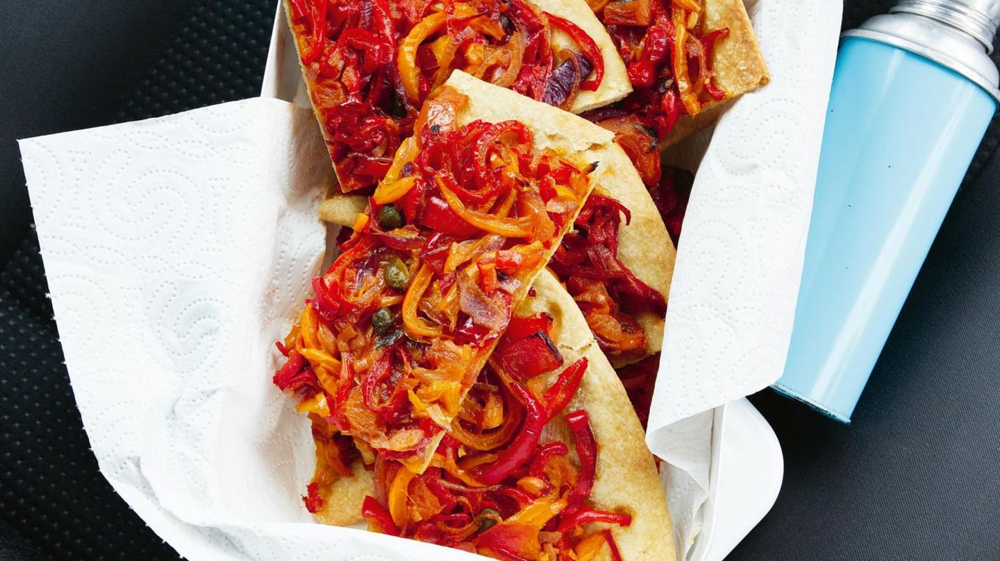 Coca "mallorquin"  Irgendwo zwischen Pizza und Gemüseblechkuchen liegt die mallorquinische Coca. Basis ist ein genialer Knetmürbteig, bei dem bestes Olivenöl und Schmalz statt Butter verwendet werden. Herzhaft belegt wird die Original-Coca gerne mit kleingeschnippeltem, rohem Gemüse. Für meine Variante habe ich ein saftiges Paprika-Tomaten-Gemüse geschmort. Der sättigende Blechkuchen schmeckt warm und kalt – auch schon auf der Reise in den Urlaub!      Zutaten:  Für 1 Blech (4 Personen)  Fertig in ca. 75 Minuten (die Zeit zum Abkühlen und Backen schon eingerechnet)  Belag  - 3 bunte Paprikaschoten (rot, gelb, orange, zusammen ca. 750 g)  - Salz 200 g (rote) Zwiebeln 3 Tomaten (ca. 300 g) 4 EL Olivenöl 2–3 Sardellen (optional) 1 Knoblauchzehe 1–2 TL Kapern (optional)  Teig  - 100 ml Olivenöl  - 100 g Schmalz  - 150 ml kaltes Wasser  - 10 g Salz  - 500 g Weizenmehl Type 550 plus etwas mehr Mehl      Zubereitung:  1. Für den Belag die Paprikaschoten vierteln, entkernen, in feine Streifen schneiden und salzen. Die Zwiebeln halbieren, in Scheiben schneiden und salzen. Die Tomaten würfeln und salzen. Öl in einer großen Pfanne erhitzen, die Gemüse hineingeben und bei mittlerer Hitze ca. 20–25 Minuten weich schmorbraten. Sie sind fertig, wenn sie nicht mehr deutlich in der eigenen Flüssigkeit köcheln, sondern weich und saftig, beinahe cremig sind.  2. Die Sardellen fein hacken. Knoblauch pellen, in feine Scheiben schneiden und mit Kapern und Sardellen 1 Minute mit den Gemüsen mitschmoren. Evtl. mit Salz nachwürzen. Auf einem Blech ausgebreitet rasch abkühlen lassen.  3. Für den Teig Olivenöl und Schmalz mit dem kalten Wasser und Salz in einer Schüssel mischen. Mehl zugeben und mit den Fingern vermischen, dann mit den Händen rasch kurz weiterkneten, der Teig soll weich sein und nicht mehr kleben.  4. Den Ofen auf 200 Grad schalten. Den Teig auf Backpapier ausrollen oder mit den Händen auf dem Blech ausbreiten (so macht man es auf Mallorca), drumherum einen kleinen Rand formen. Das Schmorgemüse gleichmäßig darauf verteilen. Auf der mittleren Schiene 35–40 Minuten backen.