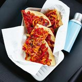 Coca "mallorquin"  Irgendwo zwischen Pizza und Gemüseblechkuchen liegt die mallorquinische Coca. Basis ist ein genialer Knetmürbteig, bei dem bestes Olivenöl und Schmalz statt Butter verwendet werden. Herzhaft belegt wird die Original-Coca gerne mit kleingeschnippeltem, rohem Gemüse. Für meine Variante habe ich ein saftiges Paprika-Tomaten-Gemüse geschmort. Der sättigende Blechkuchen schmeckt warm und kalt – auch schon auf der Reise in den Urlaub!      Zutaten:  Für 1 Blech (4 Personen)  Fertig in ca. 75 Minuten (die Zeit zum Abkühlen und Backen schon eingerechnet)  Belag  - 3 bunte Paprikaschoten (rot, gelb, orange, zusammen ca. 750 g)  - Salz 200 g (rote) Zwiebeln 3 Tomaten (ca. 300 g) 4 EL Olivenöl 2–3 Sardellen (optional) 1 Knoblauchzehe 1–2 TL Kapern (optional)  Teig  - 100 ml Olivenöl  - 100 g Schmalz  - 150 ml kaltes Wasser  - 10 g Salz  - 500 g Weizenmehl Type 550 plus etwas mehr Mehl      Zubereitung:  1. Für den Belag die Paprikaschoten vierteln, entkernen, in feine Streifen schneiden und salzen. Die Zwiebeln halbieren, in Scheiben schneiden und salzen. Die Tomaten würfeln und salzen. Öl in einer großen Pfanne erhitzen, die Gemüse hineingeben und bei mittlerer Hitze ca. 20–25 Minuten weich schmorbraten. Sie sind fertig, wenn sie nicht mehr deutlich in der eigenen Flüssigkeit köcheln, sondern weich und saftig, beinahe cremig sind.  2. Die Sardellen fein hacken. Knoblauch pellen, in feine Scheiben schneiden und mit Kapern und Sardellen 1 Minute mit den Gemüsen mitschmoren. Evtl. mit Salz nachwürzen. Auf einem Blech ausgebreitet rasch abkühlen lassen.  3. Für den Teig Olivenöl und Schmalz mit dem kalten Wasser und Salz in einer Schüssel mischen. Mehl zugeben und mit den Fingern vermischen, dann mit den Händen rasch kurz weiterkneten, der Teig soll weich sein und nicht mehr kleben.  4. Den Ofen auf 200 Grad schalten. Den Teig auf Backpapier ausrollen oder mit den Händen auf dem Blech ausbreiten (so macht man es auf Mallorca), drumherum einen kleinen Rand formen. Das Schmorgemüse gleichmäßig darauf verteilen. Auf der mittleren Schiene 35–40 Minuten backen.