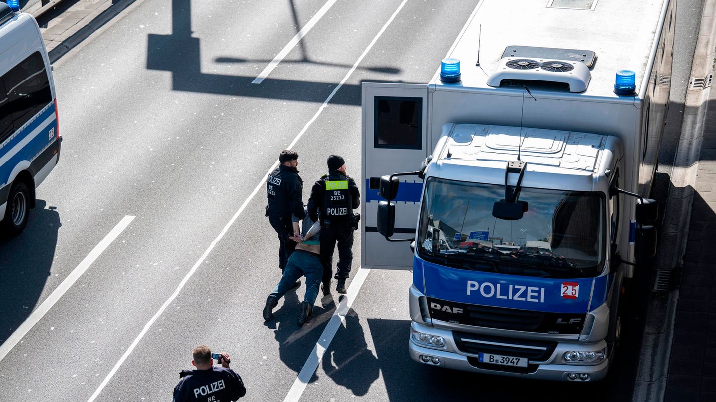Polizisten schleifen einen Aktivisten von der A100 zu einem Gefangenentransport. Bislang haben die Beamten mehr als 40 Aktivisten in Gewahrsam genommen. Dort werde "über weitere Maßnahmen entschieden", schreibt die Polizei im Kurzbotschaftendienst Twitter. Nun werde geprüft, ob die Protestteilnehmer einem Richter vorgeführt werden.