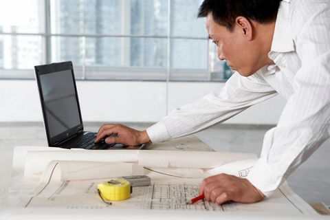 Forsa-Umfrage: Ein Mann beugt sich über den Schreibtisch und tippt auf dem Laptop