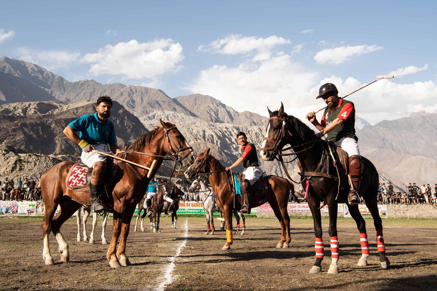 Stolz und kampfbereit stehen die Teams beim Line-up vor der Bergkulisse bei Gilgit. Helme, Handschuhe und Bandagen sind beim Freestyle-Polo keine Pflicht