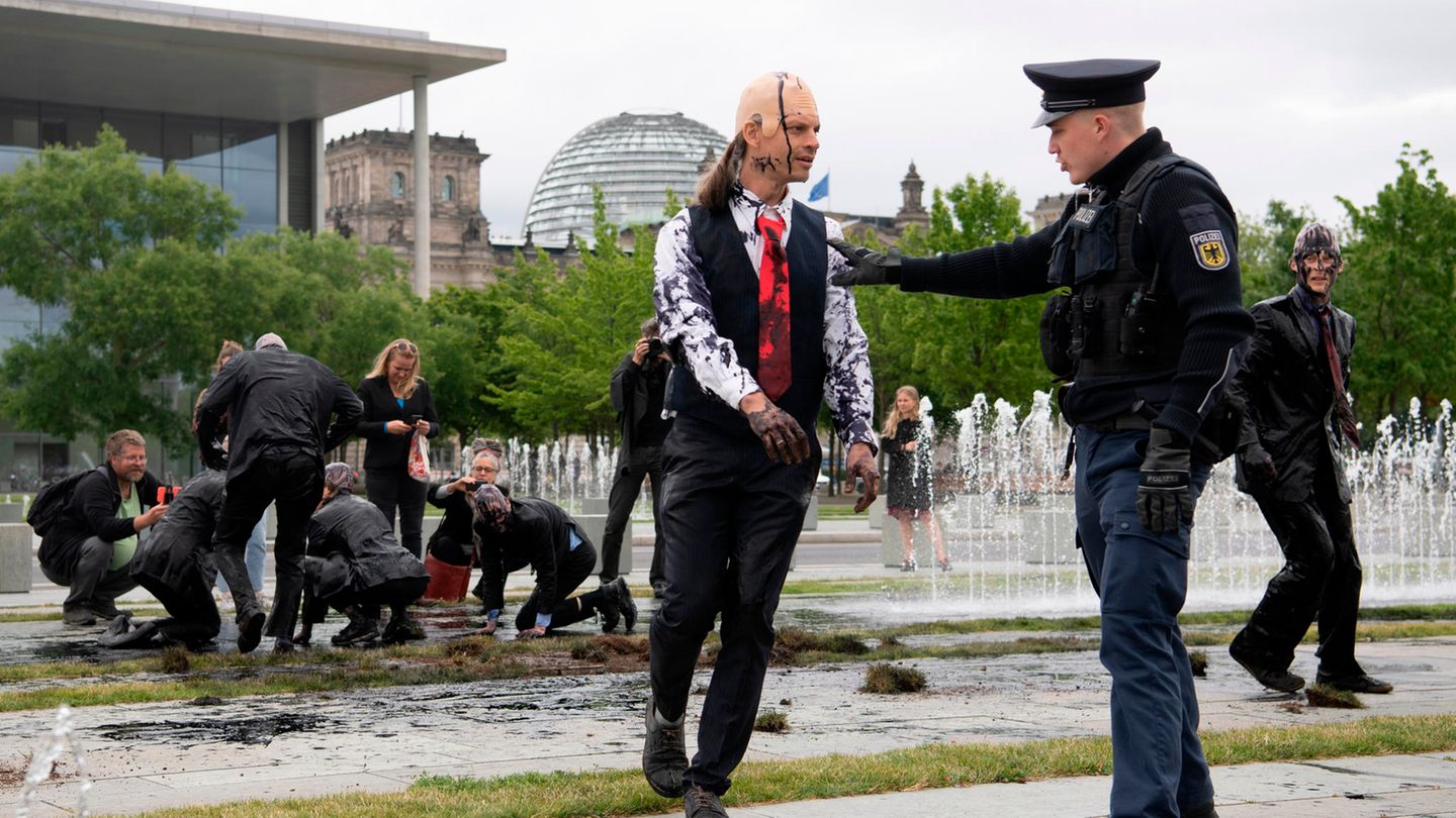 Die Ampel-Koalition und die "Letzte Generation" Juli 2022 in Berlin: Polizeibeamte stehen vor dem Kanzleramt bei Klimaschutz-Aktivisten der Gruppe "Letzte Generation". Zuvor hatten die Aktivisten als Bundeskanzler Scholz verkleidet vor dem Kanzleramt eine öl-ähnliche Farbsubstanz verschüttet, die Grasflächen aufgerissen, um nach eigenen Angaben nach Öl zu bohren.
