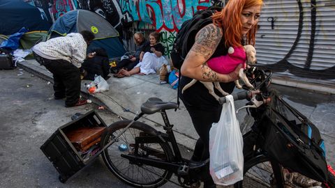 Eine Frau trägt ihren Hund im bekannten Drogenviertel in Tenderloin