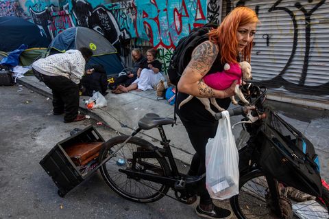 Eine Frau trägt ihren Hund im bekannten Drogenviertel in Tenderloin