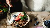 Tipp 5: Verändern Sie die Art Ihrer Grundnahrungsmittel  Wählen Sie Brot mit einem hohen Anteil an Ballaststoffen, Samen und ohne Zuckerzusatz. Wenn man gemischte Nüsse und Samen zu Naturjoghurt mit polyphenolreichen Beeren wie beispielsweise Blaubeeren hinzufügt, kann man ein nahrhaftes Frühstück genießen, das den Blutzuckerspiegel nicht in die Höhe treibt. Wenn Sie Ihrem Joghurt einen zusätzlichen probiotischen Schub geben wollen, fügen Sie einfach einen Spritzer Kefir hinzu. Wer täglich fermentierte Lebensmittel zu sich nehmen möchte, sollte Miso-Pasta anstelle von Brühwürfeln verwenden, so Spector. Das gibt den Gerichten Geschmack und Umami. Schließlich kann man weißen Reis und weiße Nudeln einfach durch Vollkornprodukte ersetzen. Reis durch Perlgraupen und Buchweizen anstelle von Couscous und Dinkelspaghetti anstelle von einfachen weißen Spaghetti.