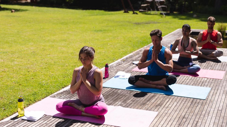 Vier Menschen praktizieren Yoga