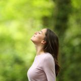 Frau atmet tief ein in der Natur
