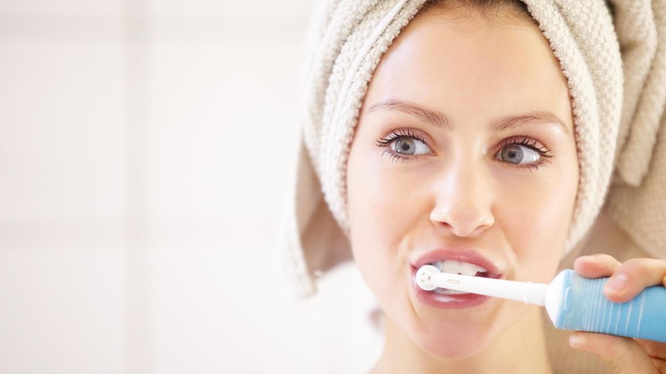 Eine Frau putzt sich die Zähne.