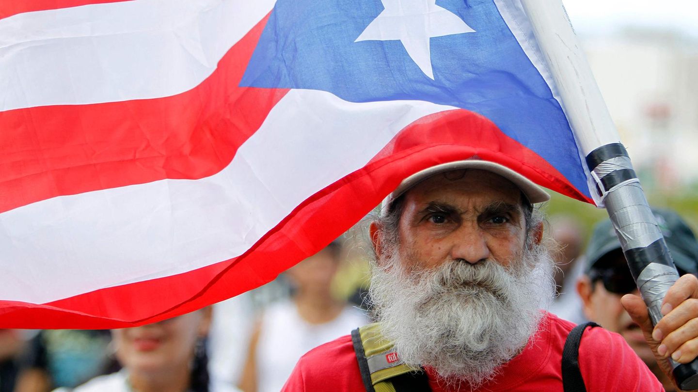 Ein älterer Mann mit einer Flagge von Puerto Rico