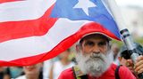 Ein älterer Mann mit einer Flagge von Puerto Rico