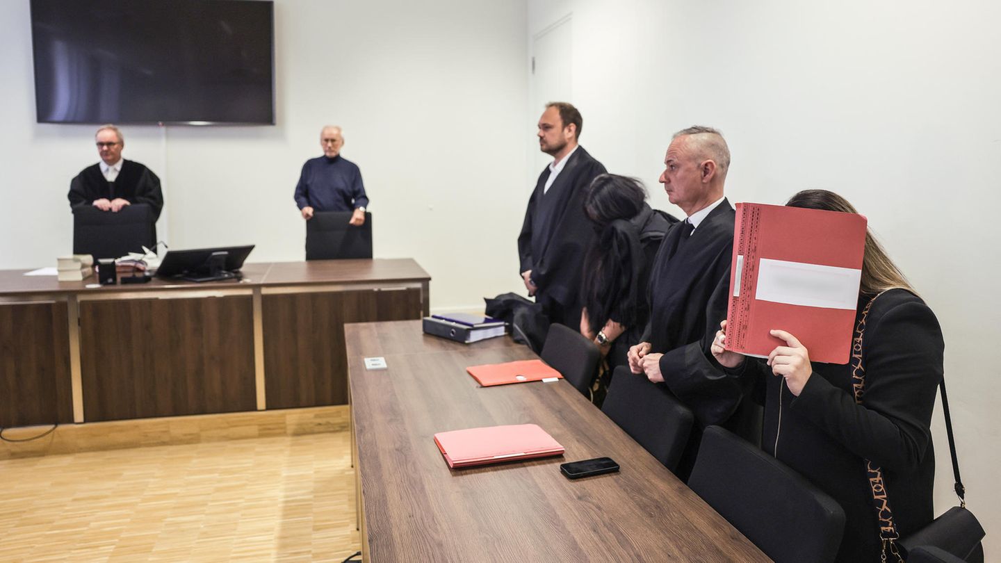 Anwälte und angeklagte Erzieherinnen stehen im Sitzungssaal des Amtsgerichts Gelsenkirchen