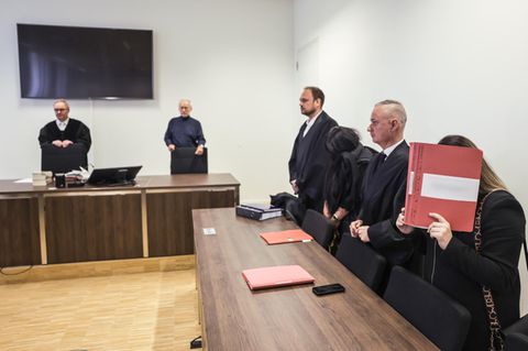 Anwälte und angeklagte Erzieherinnen stehen im Sitzungssaal des Amtsgerichts Gelsenkirchen