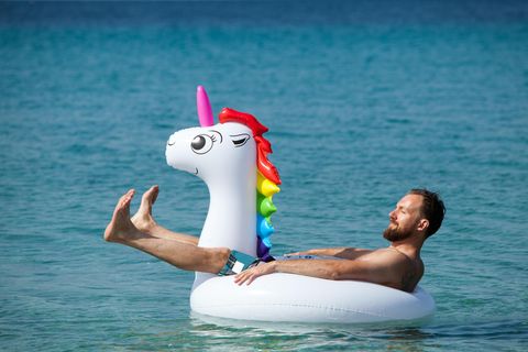 Ein Mann sonnt sich auf einer Einhorn-Luftmatratze.