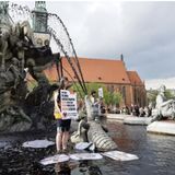 Im Märchenbrunnen steht die Aktivistin Judith Beadle mit einem Schild. Darauf steht: "In der Klimakatastrophe: Keine Kultur! Kein Wasser! Kein Leben!" Um ihre Nachricht Ausdruck zu verleihen, haben die Aktivisten der Letzten Generation das Brunnenwasser mit Pulver schwarz gefärbt. Einige überschütteten sich laut Mitteilung mit schwarzem Leim – ein Symbol für Erdöl.