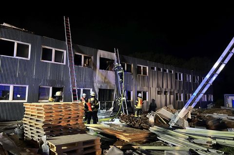 Feuerwehrleute löschen einen Brand in einer noch unbewohnten Flüchtlingsunterkunft in Hessen
