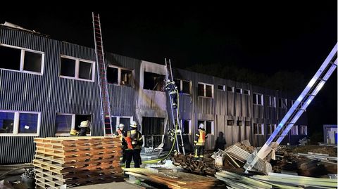 Feuerwehrleute löschen einen Brand in einer noch unbewohnten Flüchtlingsunterkunft in Hessen