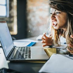 Eine genervte Frau vor dem Computer