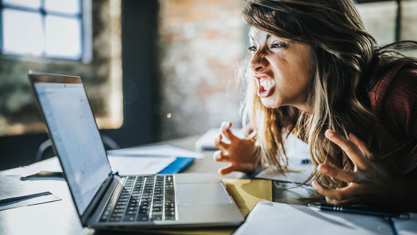 Eine genervte Frau vor dem Computer