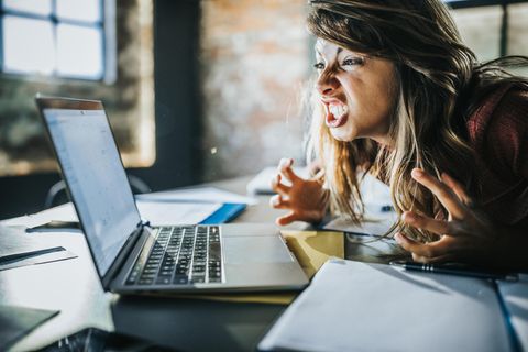 Eine genervte Frau vor dem Computer