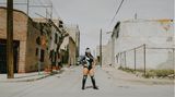 Universis wird in den Arbeitervierteln von Ciudad Juárez als Heldin gefeiert. Früher war sie Mitglied einer Straßengang. Erst der Erfolg als Luchadora ermöglichte ihr den Ausstieg aus der Szene. Das menschenleere Zentrum nahe dem Grenzzaun zu den USA, wo sie für das Porträt posiert, gilt als gefährlichster Teil der Stadt