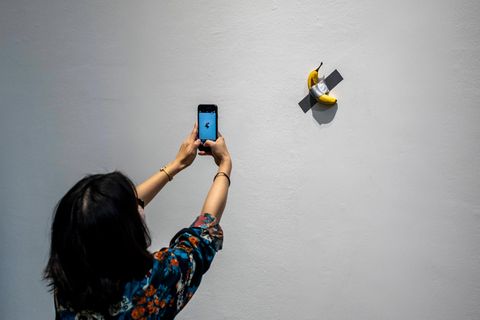 Eine Banane klebt in einer Ausstellung als Kunstwerk an der Wand