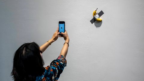 Eine Banane klebt in einer Ausstellung als Kunstwerk an der Wand