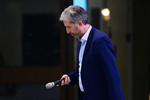 Boris Palmer senkt den Kopf und hält ein Mikro in der Hand